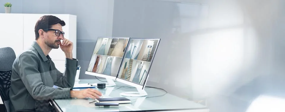 Security System Operator Looking At CCTV Footage Foto stock