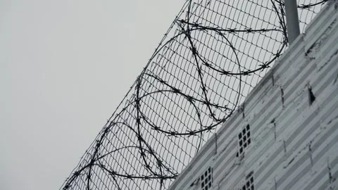 Security systems restricted area. Sharp razor blades on barbed wire. Prison wall Stock Footage 328146172