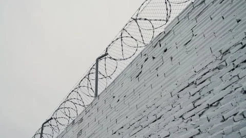 Security systems restricted area. Sharp razor blades on barbed wire. Prison wall Stock Footage 330073965