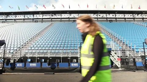 Security woman walking in front of empty stadium seats Stock Footage 45078879