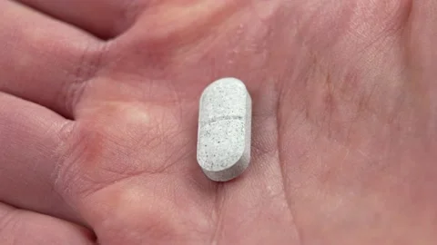 Sedative pills with tryptophan in hand close-up Stock Footage 224152300