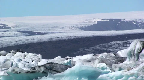Sediment loaded glacier ice behind the icebergs on lake Stock Footage 37967570