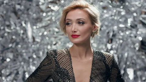 Seductive Blonde On Shiny Gray Background. She Holds Her Hands On Her Waist And Stock Footage 179087086