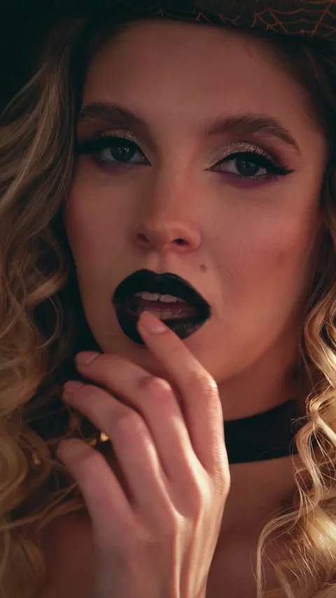 Seductive blonde witch in black lipstick, playful smile and finger to lips Stock-Footage 342068142