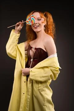 Seductive female model with lollipop in hand smiling at camera Stock Photos
