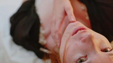 Seductive ginger girl touching her face and body while laying in bed Stock Footage 245418846