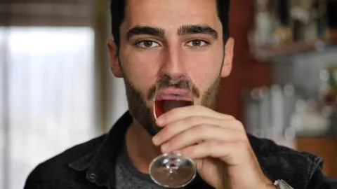 Seductive handsome young man sitting drinking Stock Photos