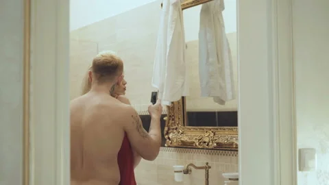 Seductive lovers going to and taking selfie at mirror in bathroom Stock Footage 86831233