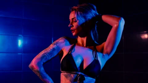 Seductive photo model takes a shower in a swimsuit, poses for a photographer Stock Footage 314565266