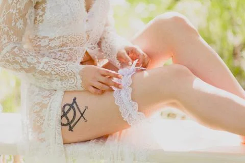 Seductive young bride dressing white garter Stock Photos