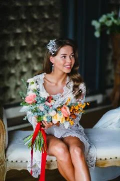 Seductive young bride posing with gorgeous bridal bouquet in the hotel room Stock-Fotos