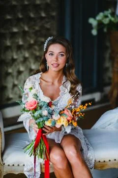 Seductive young bride posing with gorgeous bridal bouquet in the hotel room Stock Photos