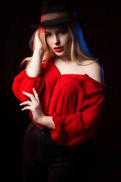 Seductive young lady with red lips posing in the shadow with blue and red lig Stock Photos