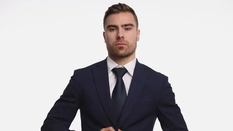 Seductive young man buttoning navy blue suit in a sensual manner, crossing arms 動画素材 142357669