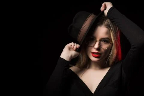 Seductive young model wearing black blouse, hat and glasses, posing in the sh Stock Photos