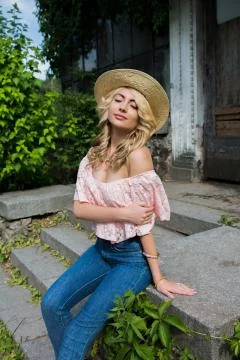 Seductive young model wearing straw hat and lace blouse with naked shoulders Stock Photos