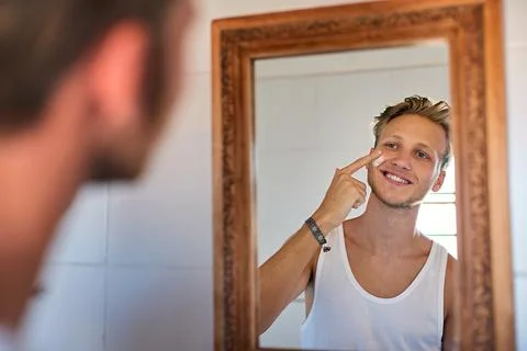 See and feel the difference after just one week. a young man applying Stock Photos
