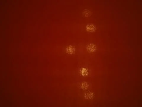 See through red cloth background, small yellow bokeh vertical row 库存照片