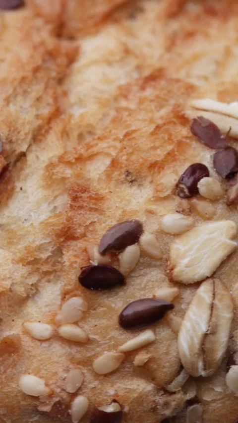 Seeded bread bun rotating in macro textured seamless loop for culinary themes Video stock 323333191