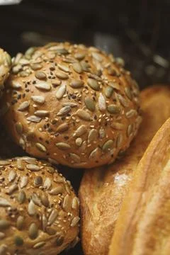 Seeded rolls and bread in a basket at a bakery Stock Photos