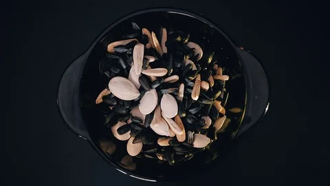 Seeds are poured from one Cup to another standing on the table. Close up Stock Footage 108945237