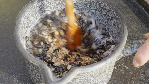 Seeds  being mixed in a pot with coconut fat to make a mixture for a bird feeder Stock Footage 86007612