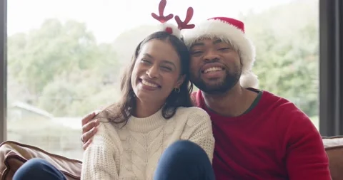 Seeing camera African American Hispanic couple laughing on sofa by window Stock Footage 342112091