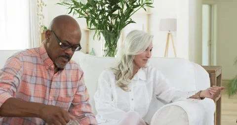 On seeing empty glasses diverse senior friends at home watching man pouring from Stock Footage 317216005