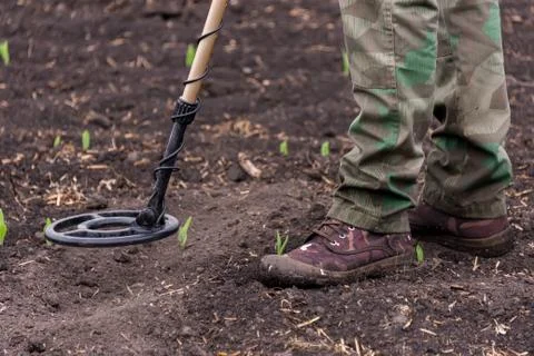 To seek treasures on earth with a metal detector Stock Photos