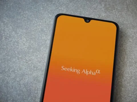 Seeking Alpha app launch screen with logo on the display of a black mobile sm Stock Photos