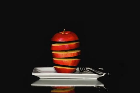Seemingly floating red apple slices on a plate Stock Photos