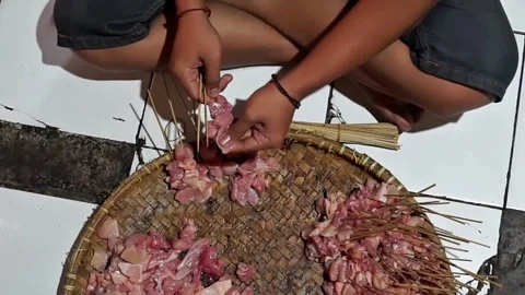 Seen from above skewering chicken meat on satay sticks Stock Footage 270347313