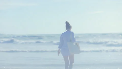 Seen from behind female having fun time and rejoicing at beach Stock Footage 229718151