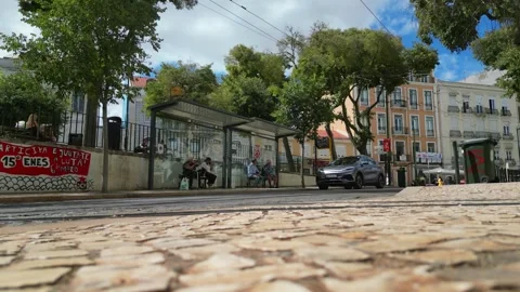 Seen from the ground a bus stop with people sitting and the tram passing by at Stock Footage 316766088