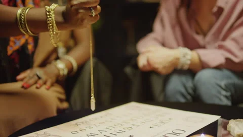 Seer Holding Pendulum over Paper with Letters Trying to Answer Clients Questions Stock Footage 247629959