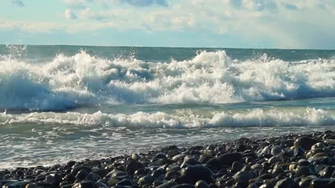 Seething waves on the rocky seashore, lots of foam and spray, blue sky Stock Footage 171603953