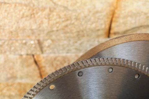 Segment of a diamond cutting disc on a background of orange-golden sandstone Foto stock