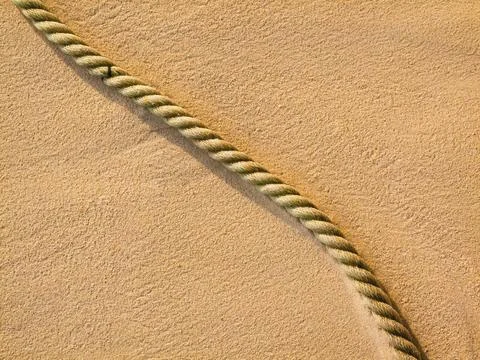 Segment of discarded rope on sand Stock Photos