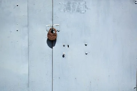 Segment of gray garage doors with padlock. Stock Photos