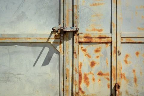 Segment of gray garage doors with rusty spots.	 Stock Photos