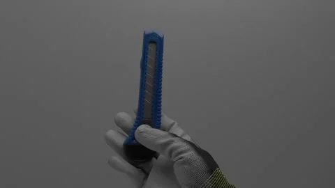 Segment knife in the hand on a gray background. Vídeo Stock 265597153