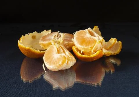 Segments of the tangerine on glass table with reflection Stock Photos