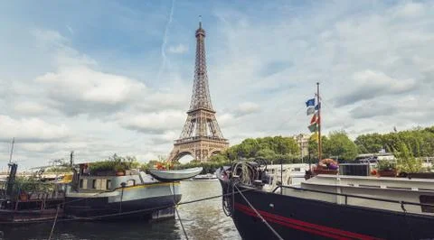 Seine in Paris with Eiffel tower at a cloudy summer day Stock Photos