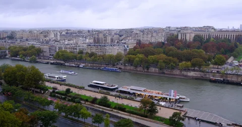 Seine River waterfront in Paris under an overcast sky, cruise boats Stock Footage 328524344