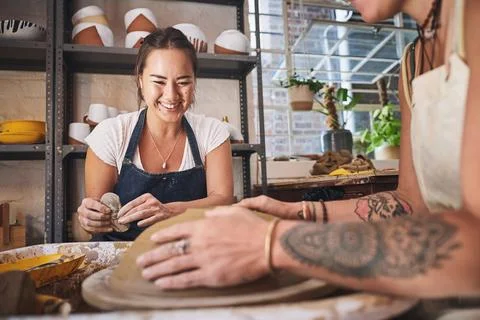 Seize the clay with both hands. two young women working with clay in a pottery Stock Photos