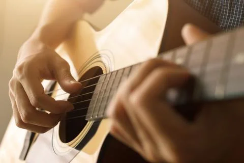 Select focus and soft focus , Man's hand playing acoustic guitar , musical co Stock Photos