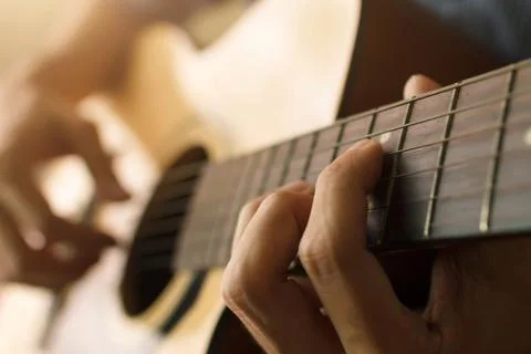 Select focus and soft focus , Man's hand playing acoustic guitar , musical co Stock Photos