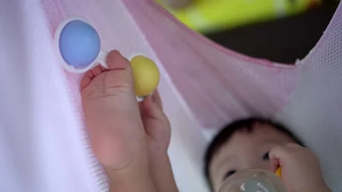 Select focus baby boy drink milk plat the plastic toy Vídeos de archivo 221538264
