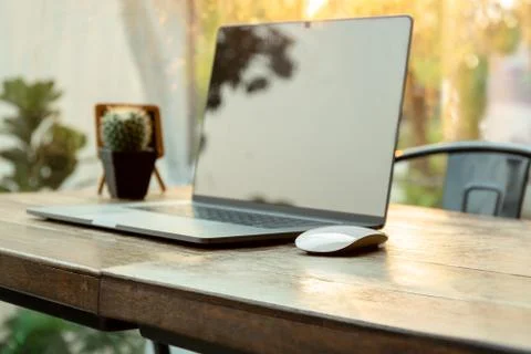 Selected focus computer mouse and laptop on wooden table in blur background. Stock Photos
