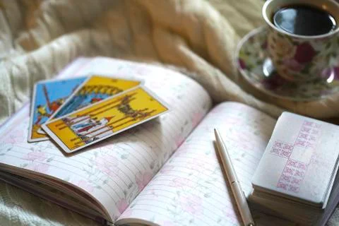 Selected focus of tarot cards layout, cup of Coffee and notebook. Stock Photos